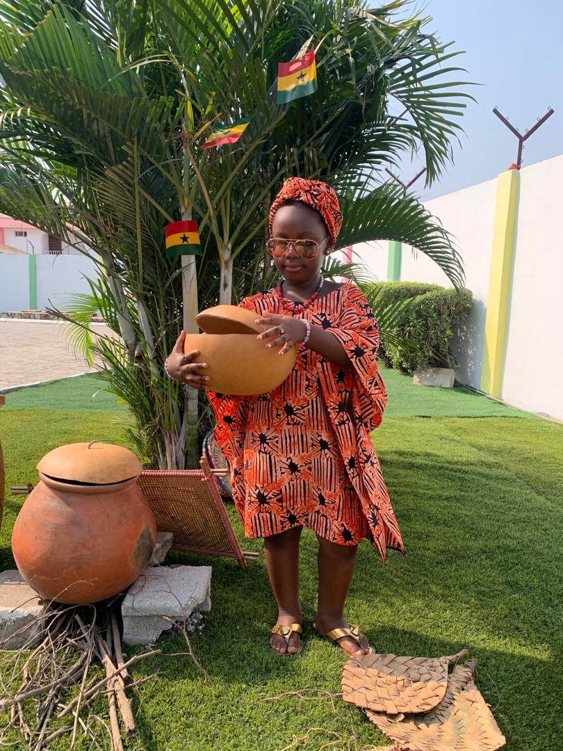 African Union Day — child in kente with pot